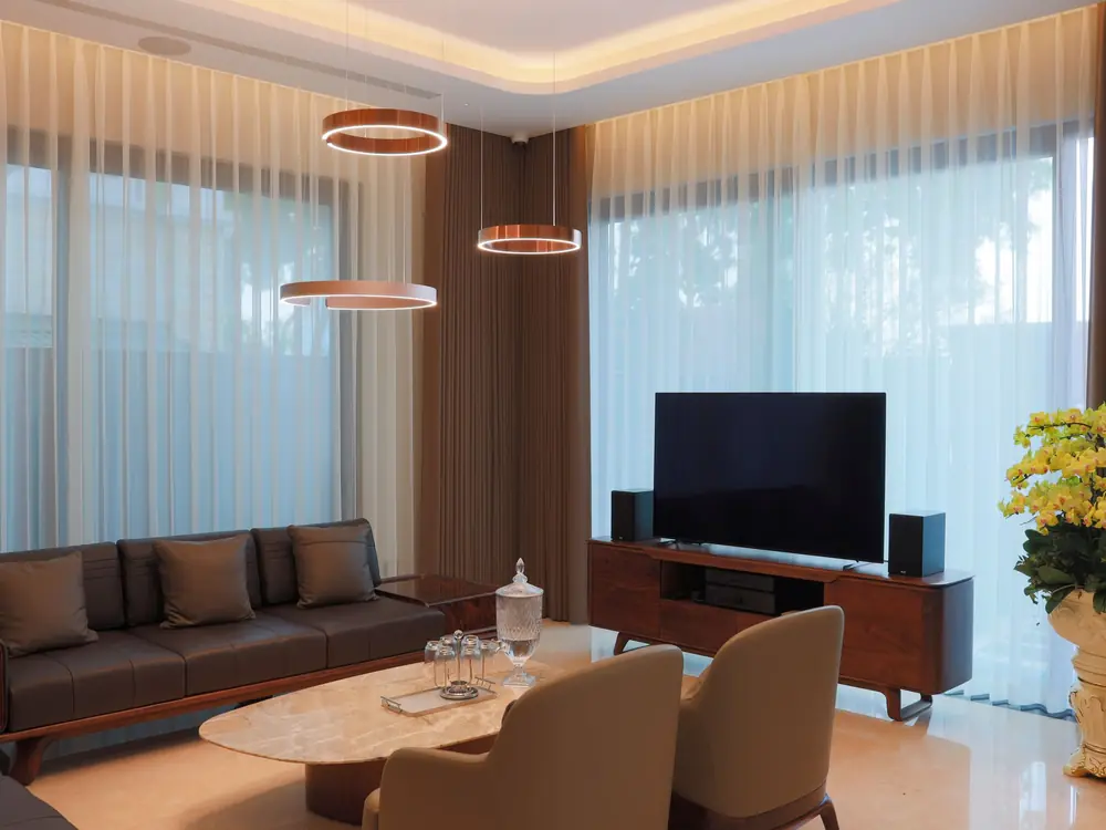 Beachfront villa lounge in Tamarin with sheer curtains and a timber feature ceiling