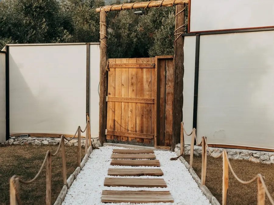 Modern boundary wall with a timber gate and a paved garden path
